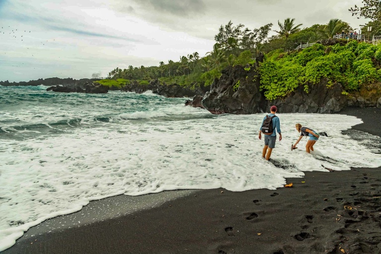 road to hana black sand beach visitors in surf waianapanapa maui
